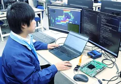 複数のモニターとノートPCに向かってソフトウェア開発を進める社員