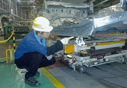 生産ラインで車体部品を点検する社員