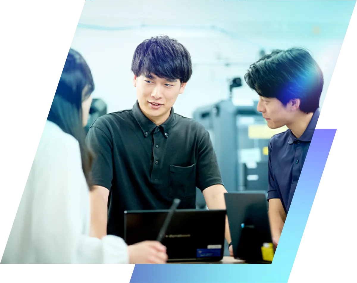 ノートPCを囲んで話し合う社員