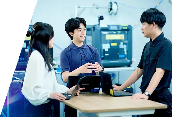 研究設備の前で打ち合わせをする社員3名